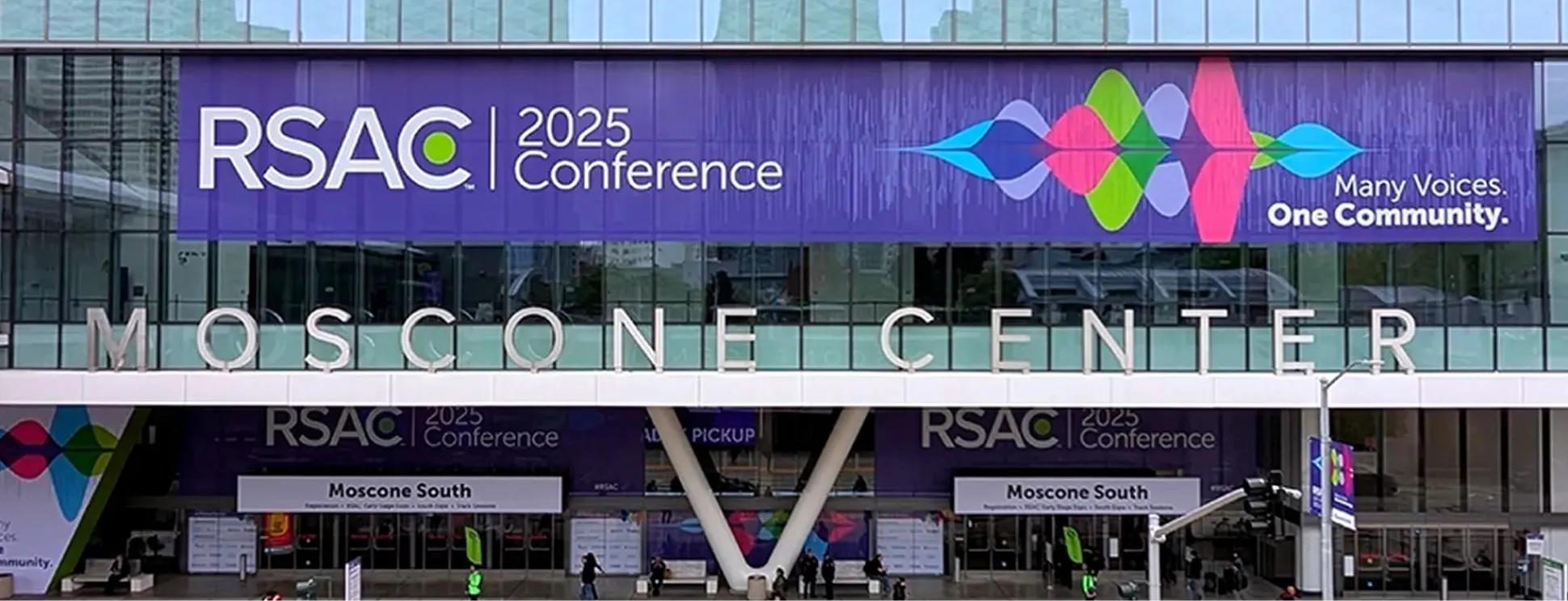 Entrance of Moscone Center with a large banner for RSAC 2025 Conference reading 'Many Voices. One Community.'