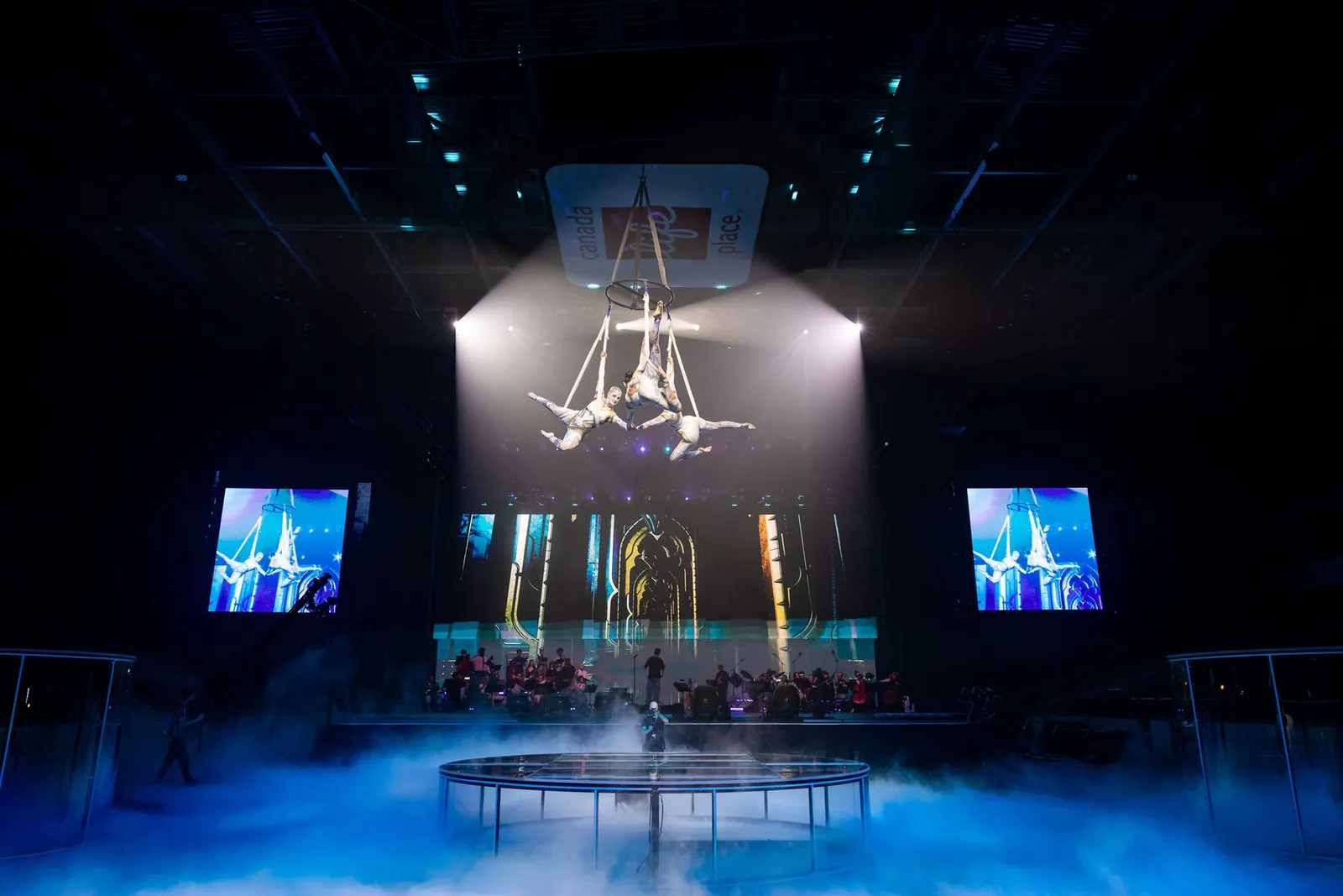 Aerial performers suspended above a smoke-filled stage at TennoCon 2026