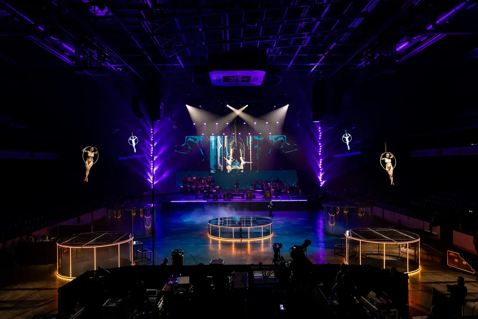 Wide view of the TennoCon 2026 arena stage with aerialists overhead