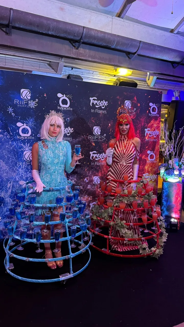 Two strolling performers in red and turquoise drink-serving dresses