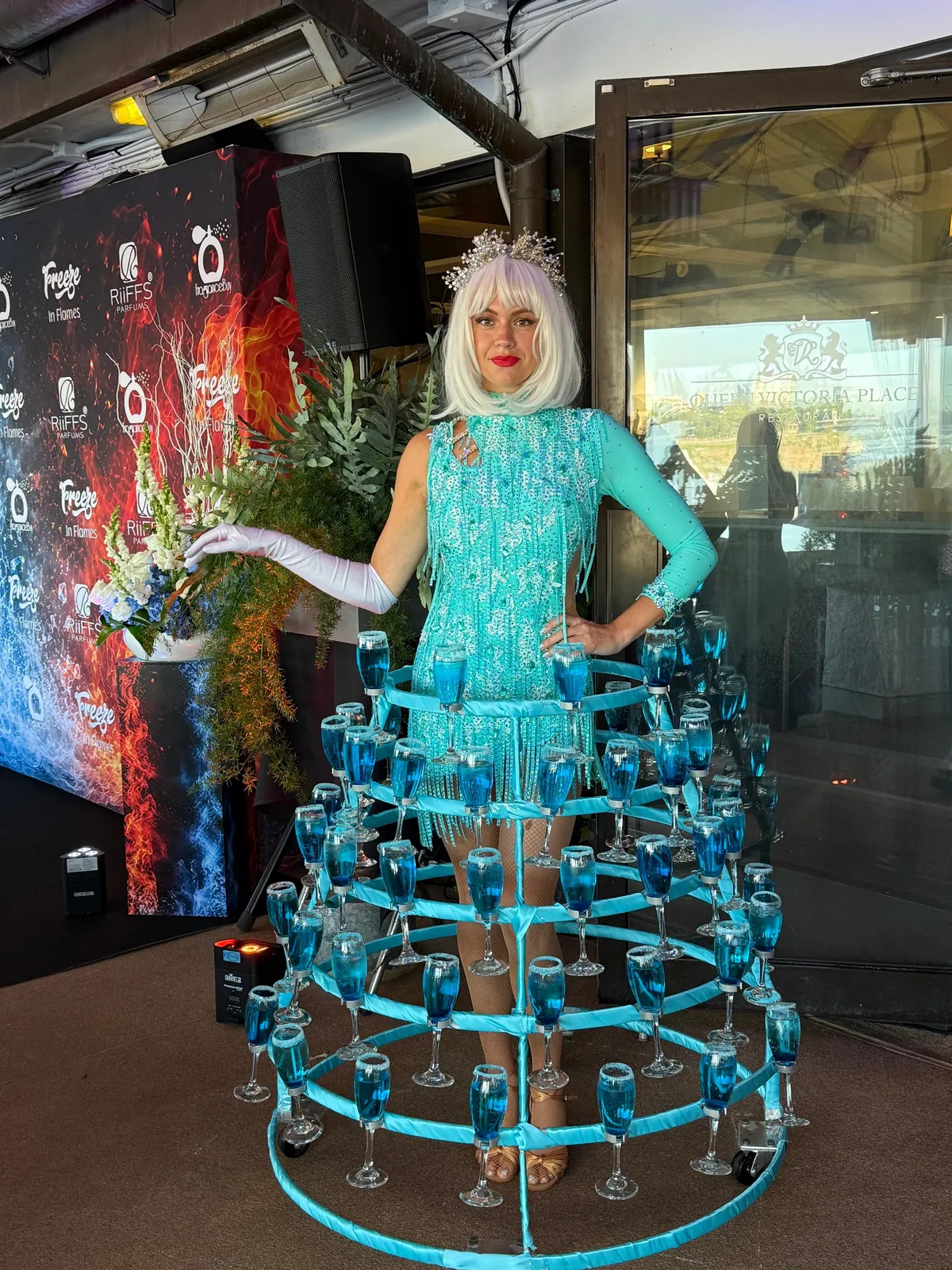 Strolling performer in a turquoise ice-themed drink-serving dress