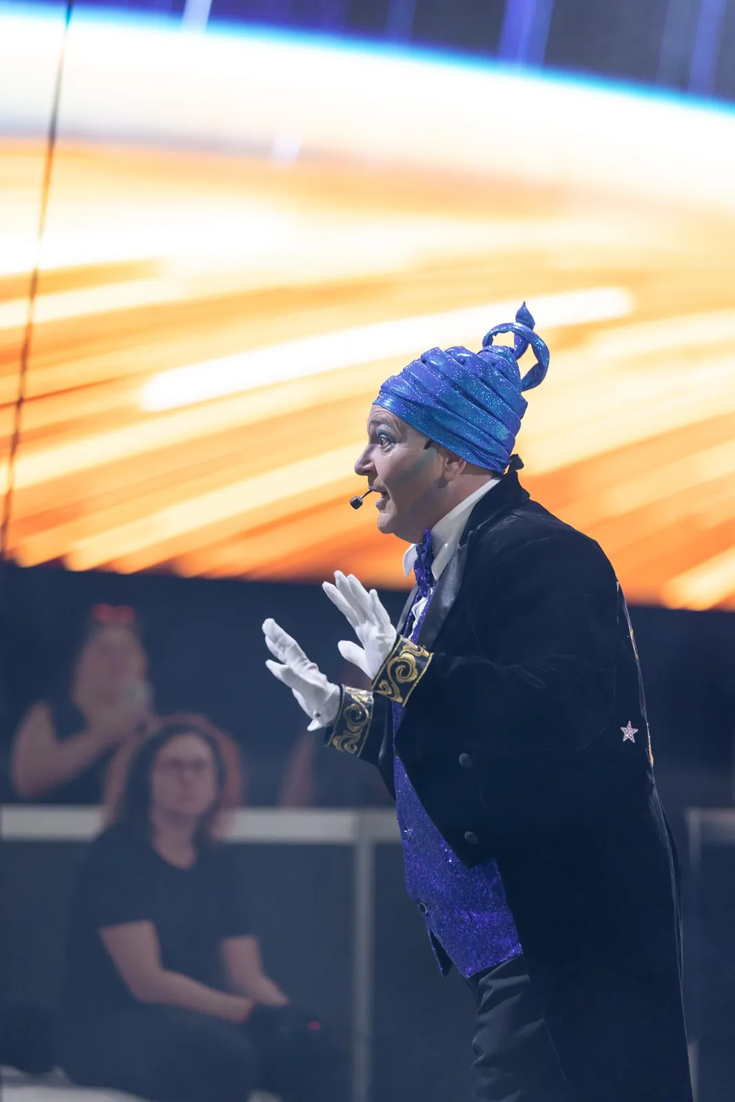 Space character in a blue costume interacting with guests