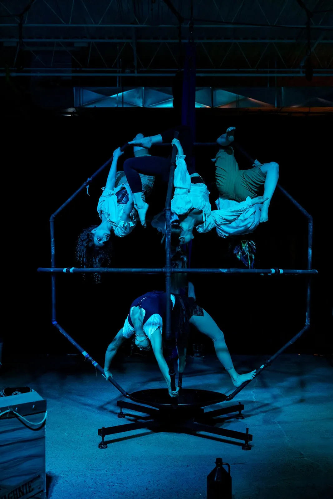 Acrobats inside the DaVinci apparatus under blue light