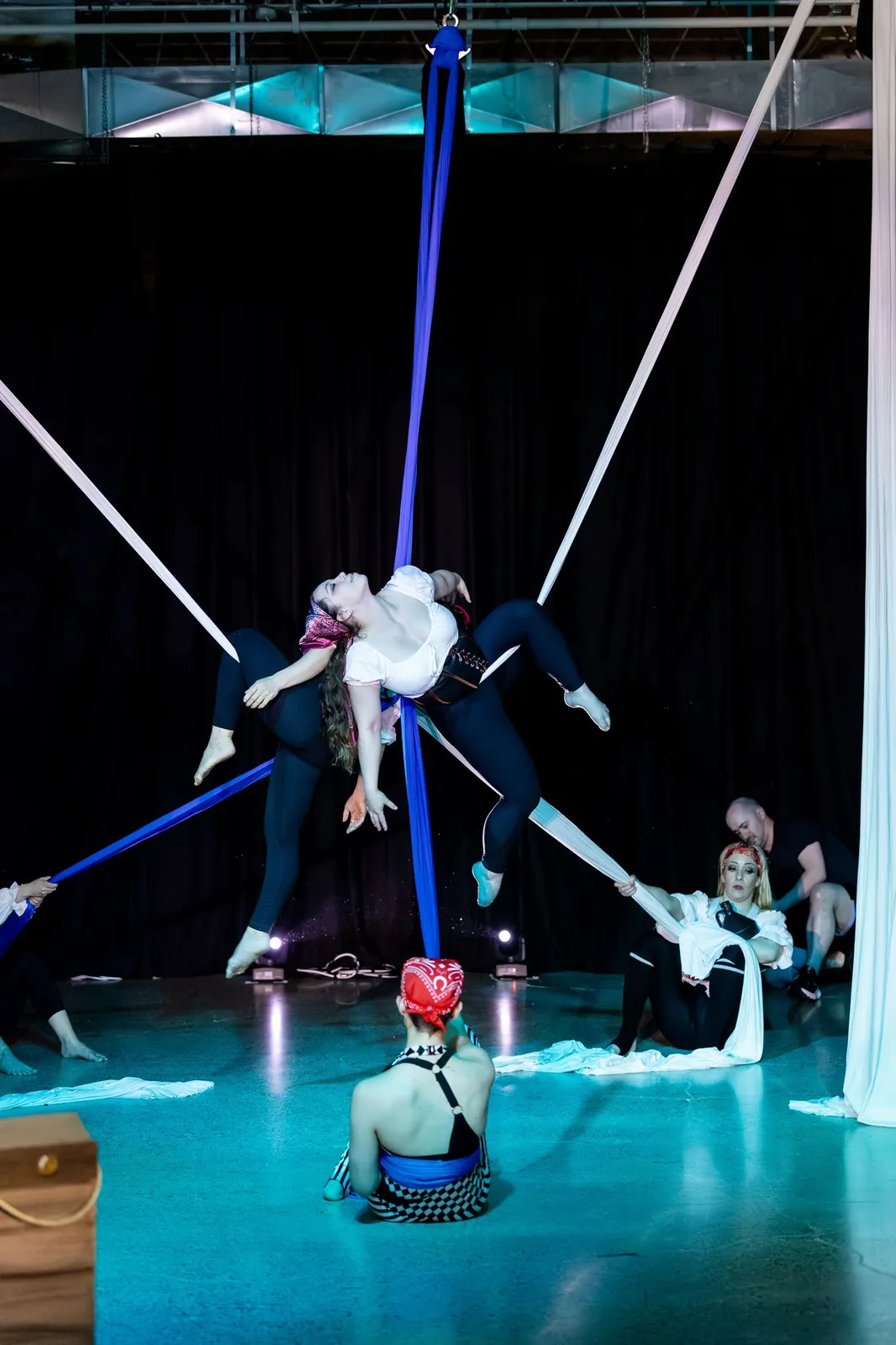 Aerialist on silks above a pirate-themed stage