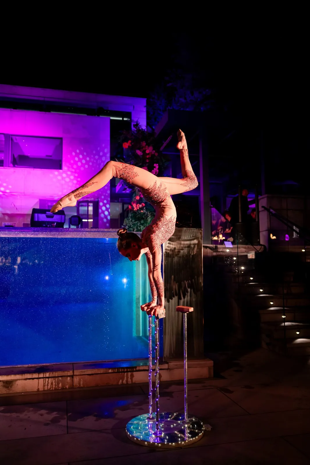 Hand balancer holding a one-arm handstand on pegs