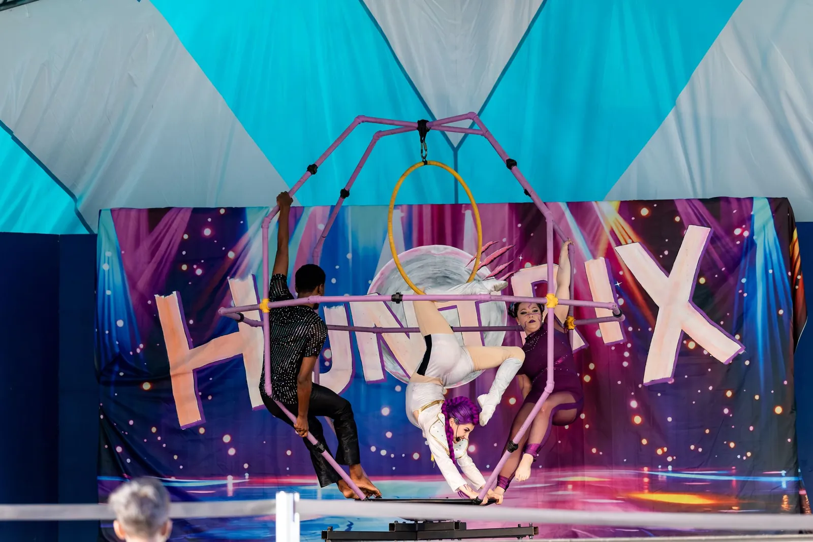 Acrobat inside the DaVinci apparatus with dancers