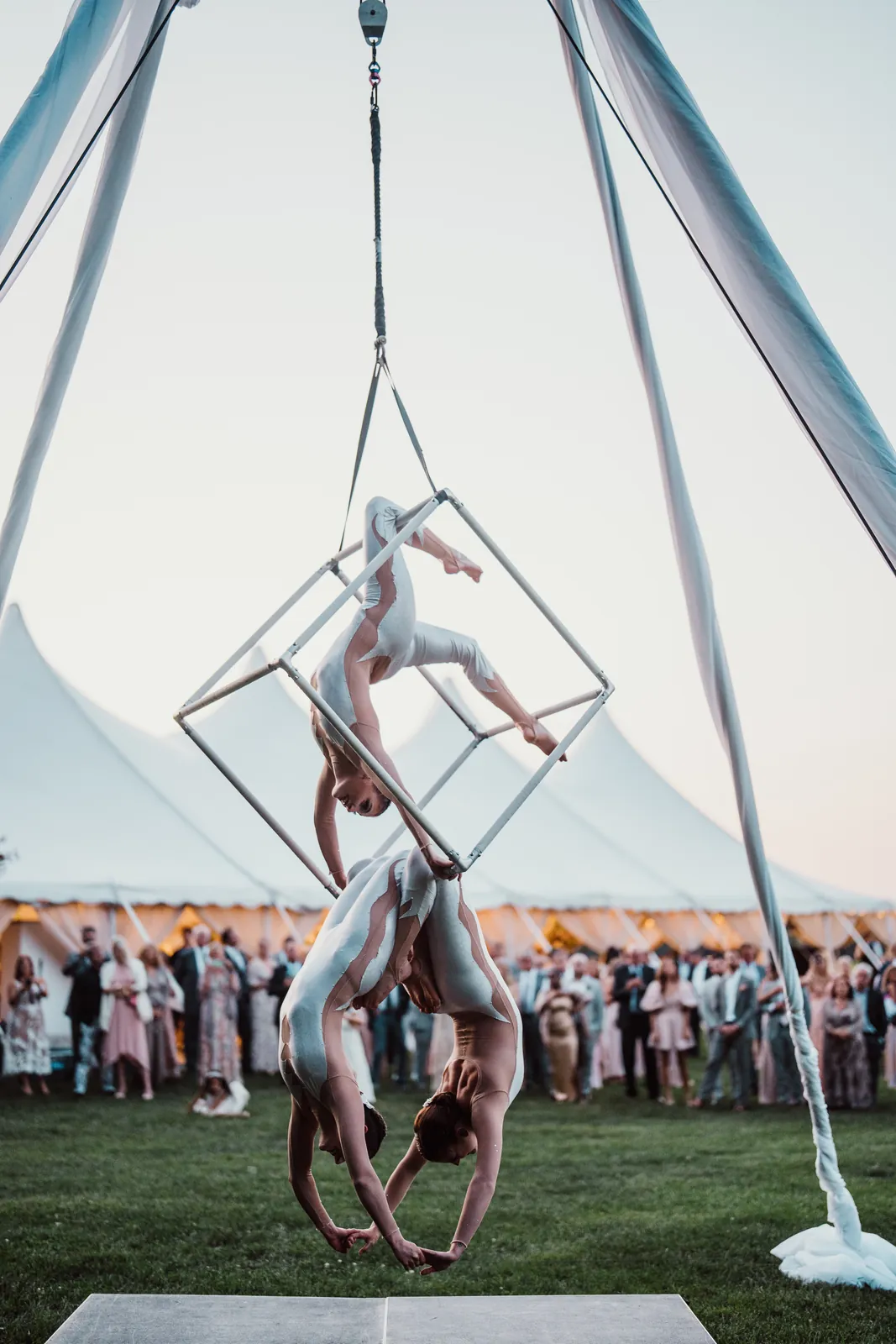 Aerial cube duo performing outdoors in front of an event tent