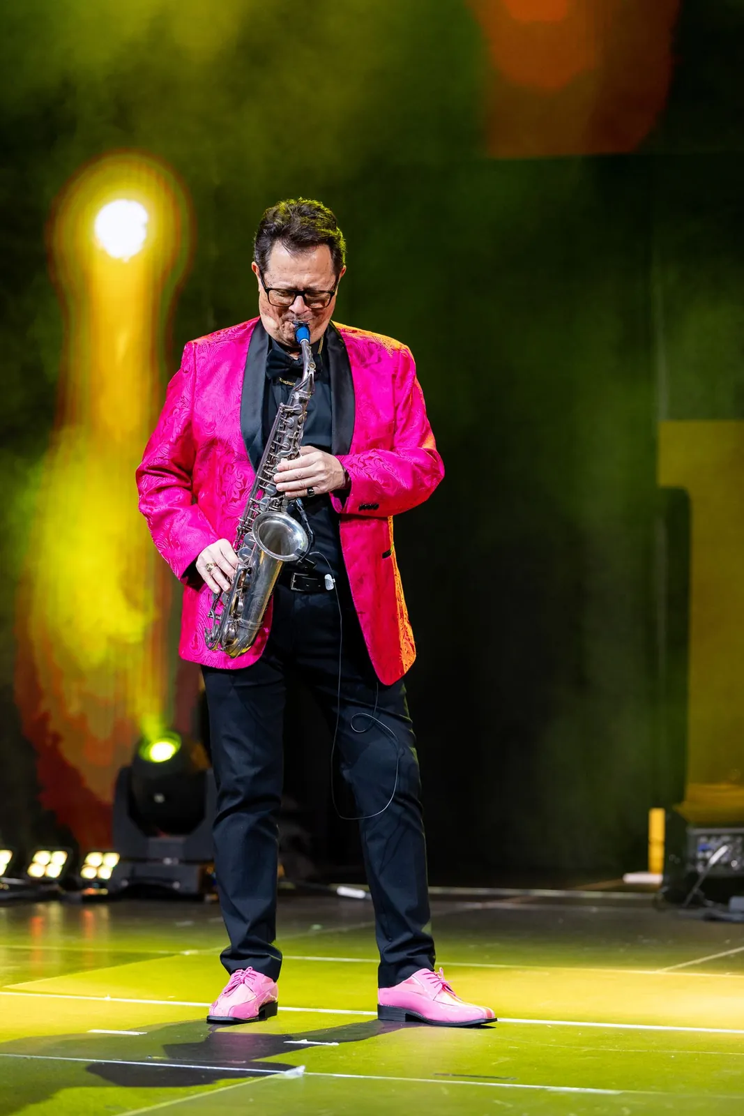 Saxophonist in a pink suit performing on stage