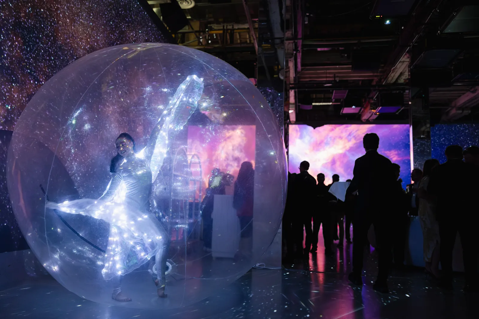 LED dancer glowing inside a clear bubble at a Starry Nights galaxy-themed event