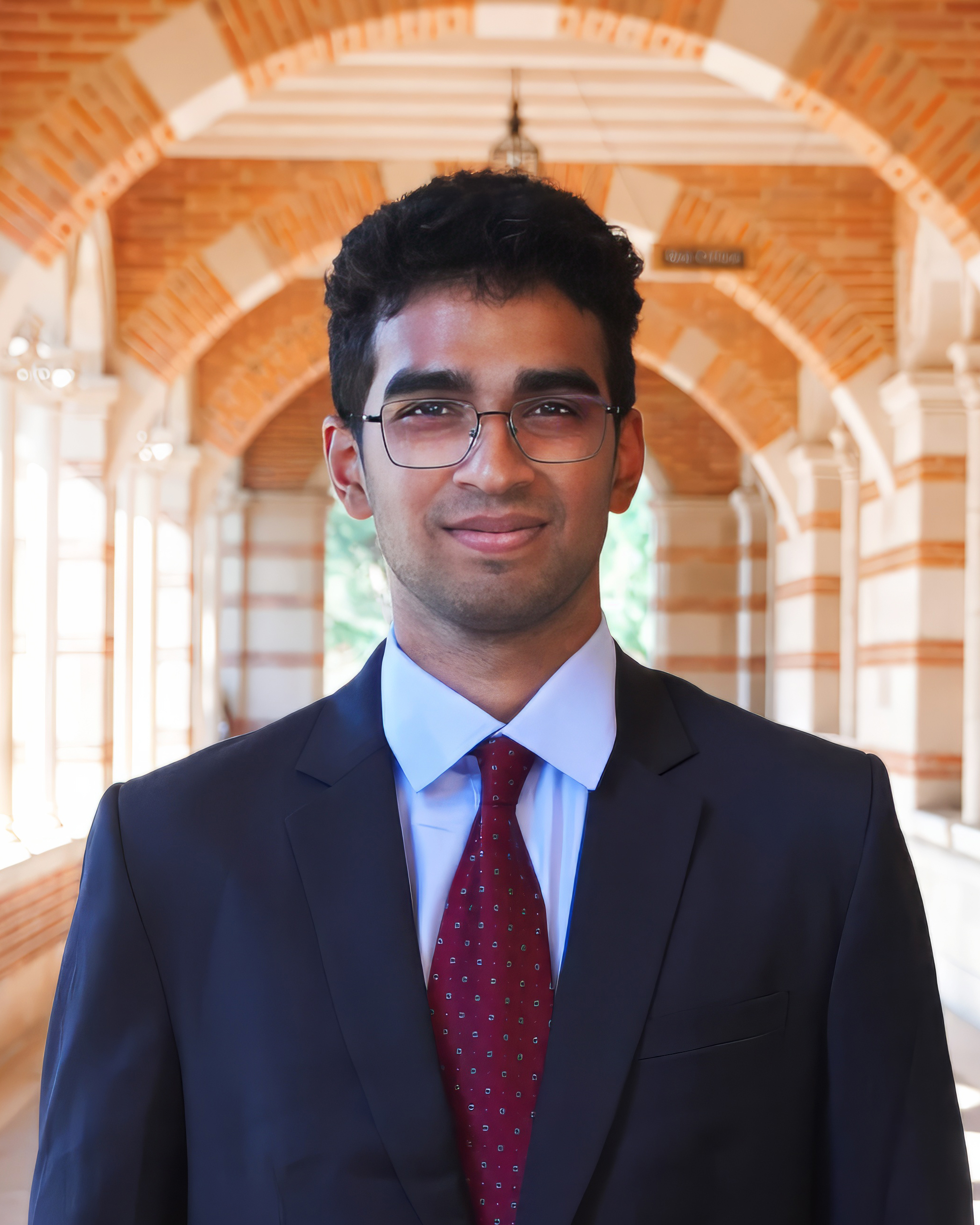 A man wearing a black suit and red tie