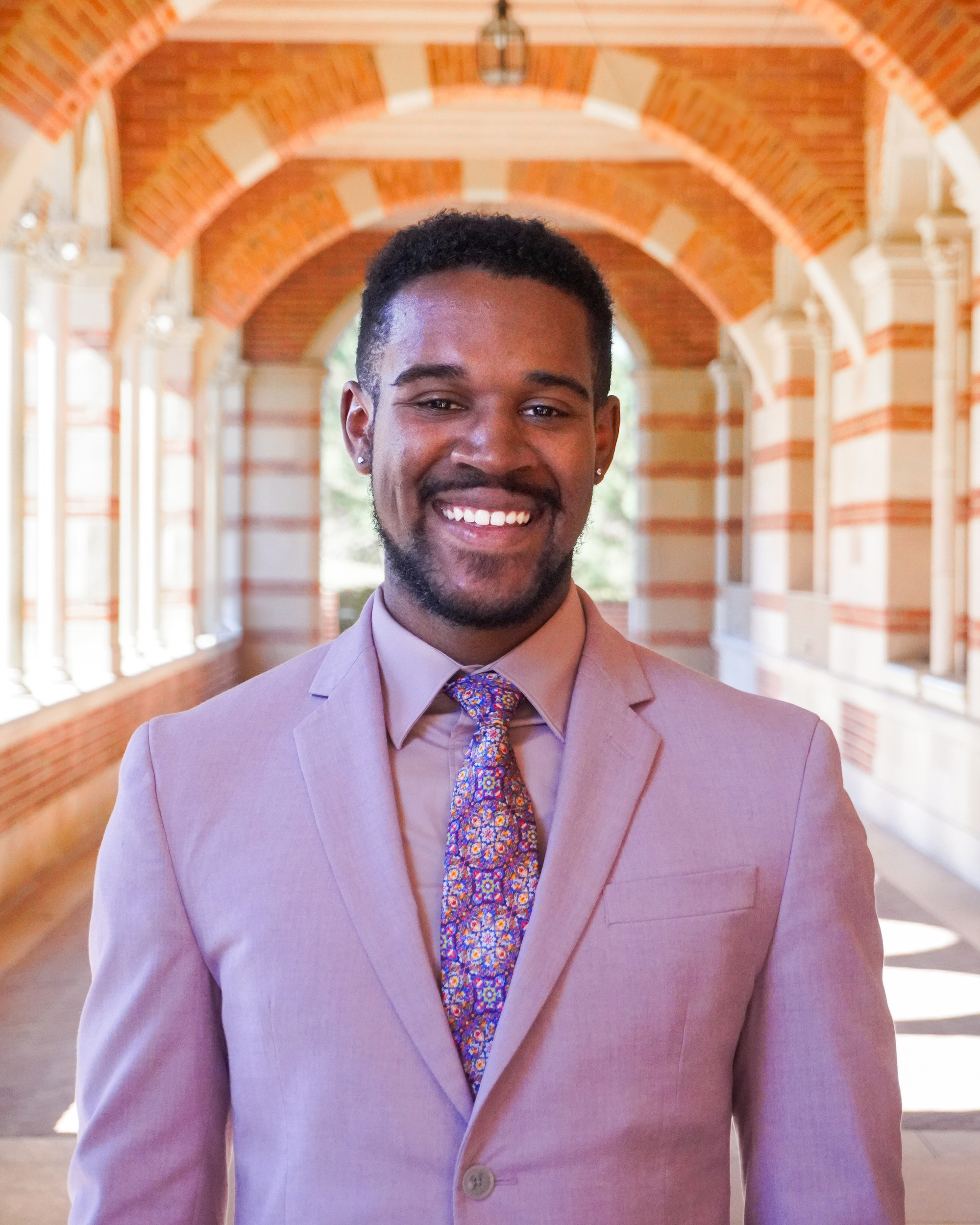 A man wearing a pink suit and pink tie