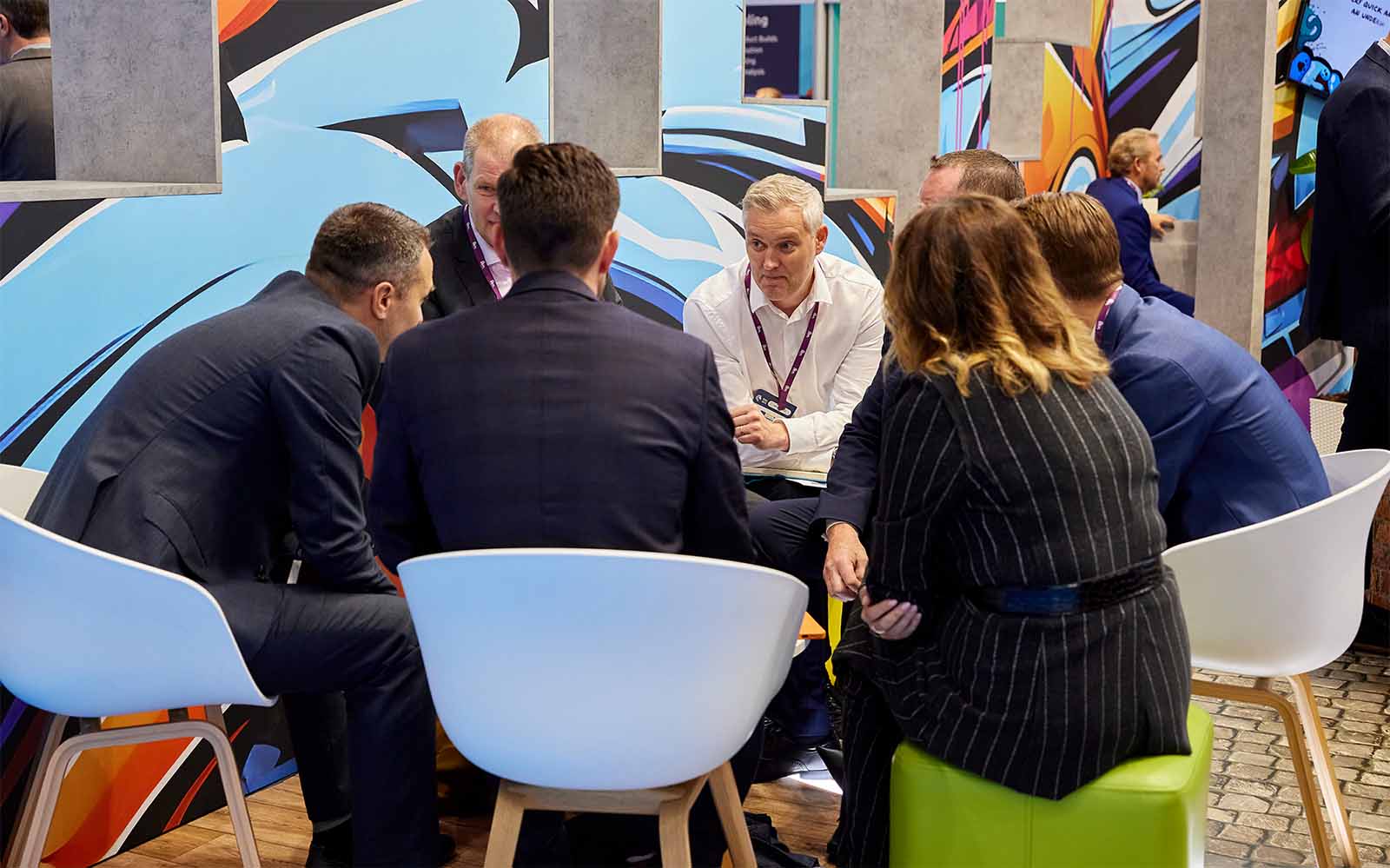 Group having a discussion in the meeting area of a conference stand