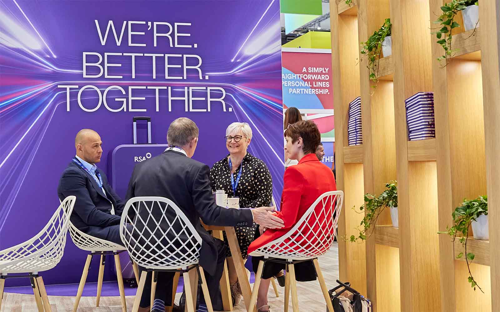 Group having a discussion in the meeting area of a conference stand