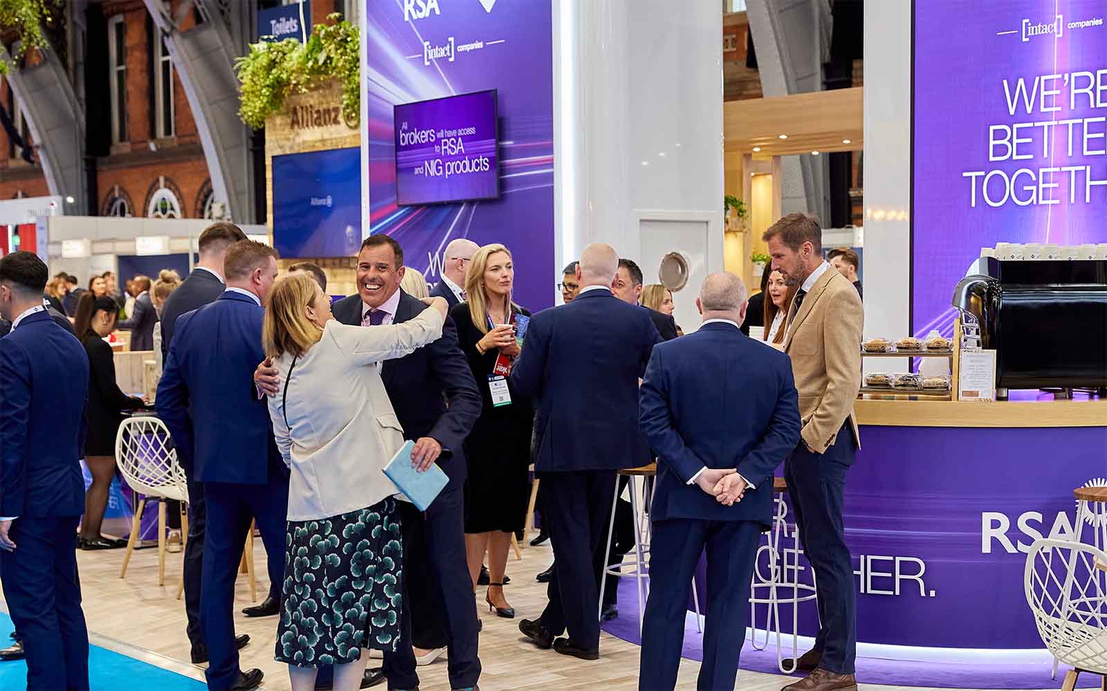 People congregated and networking in front of a conference stand