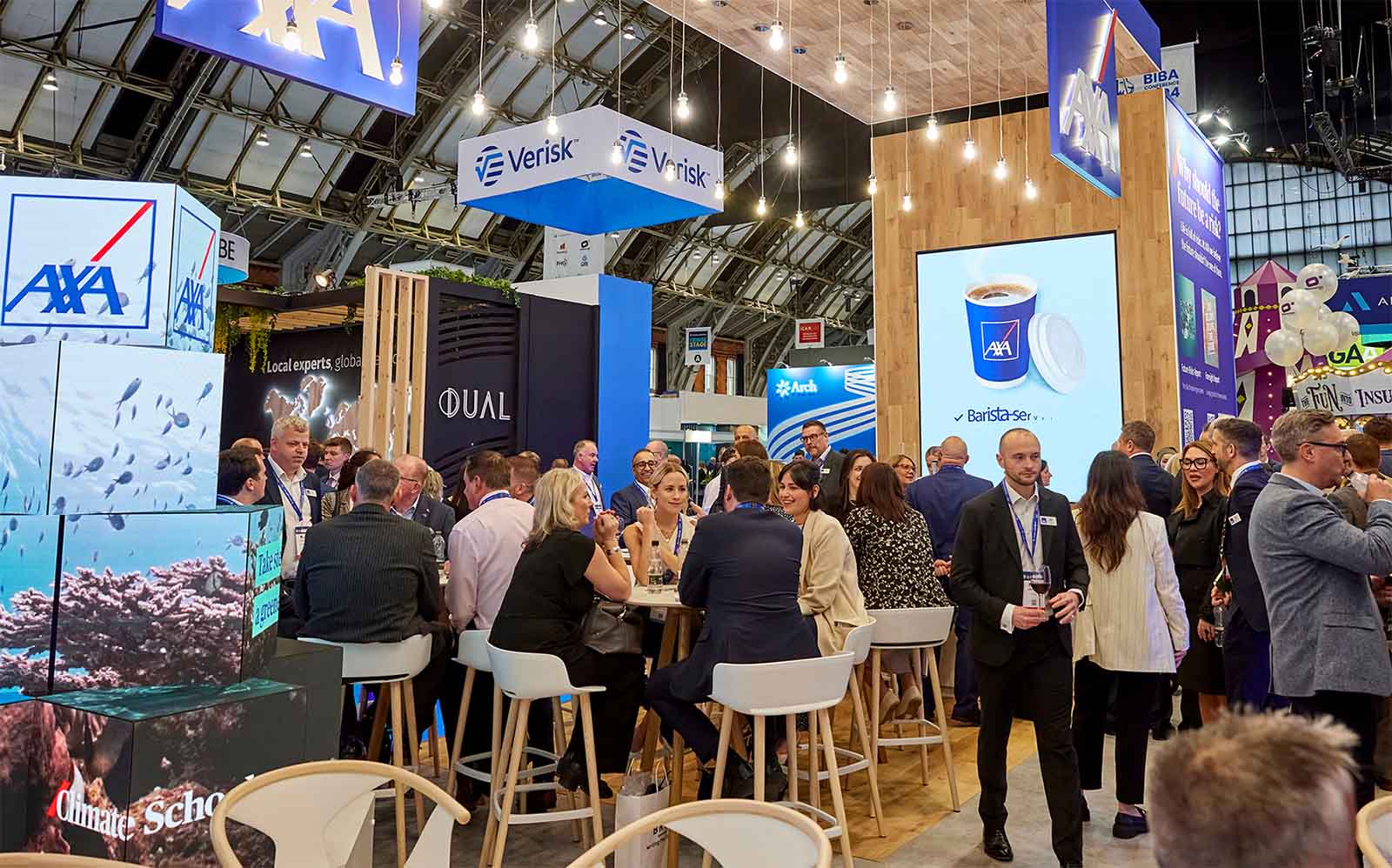 Numerous people networking and having meetings at a conference stand