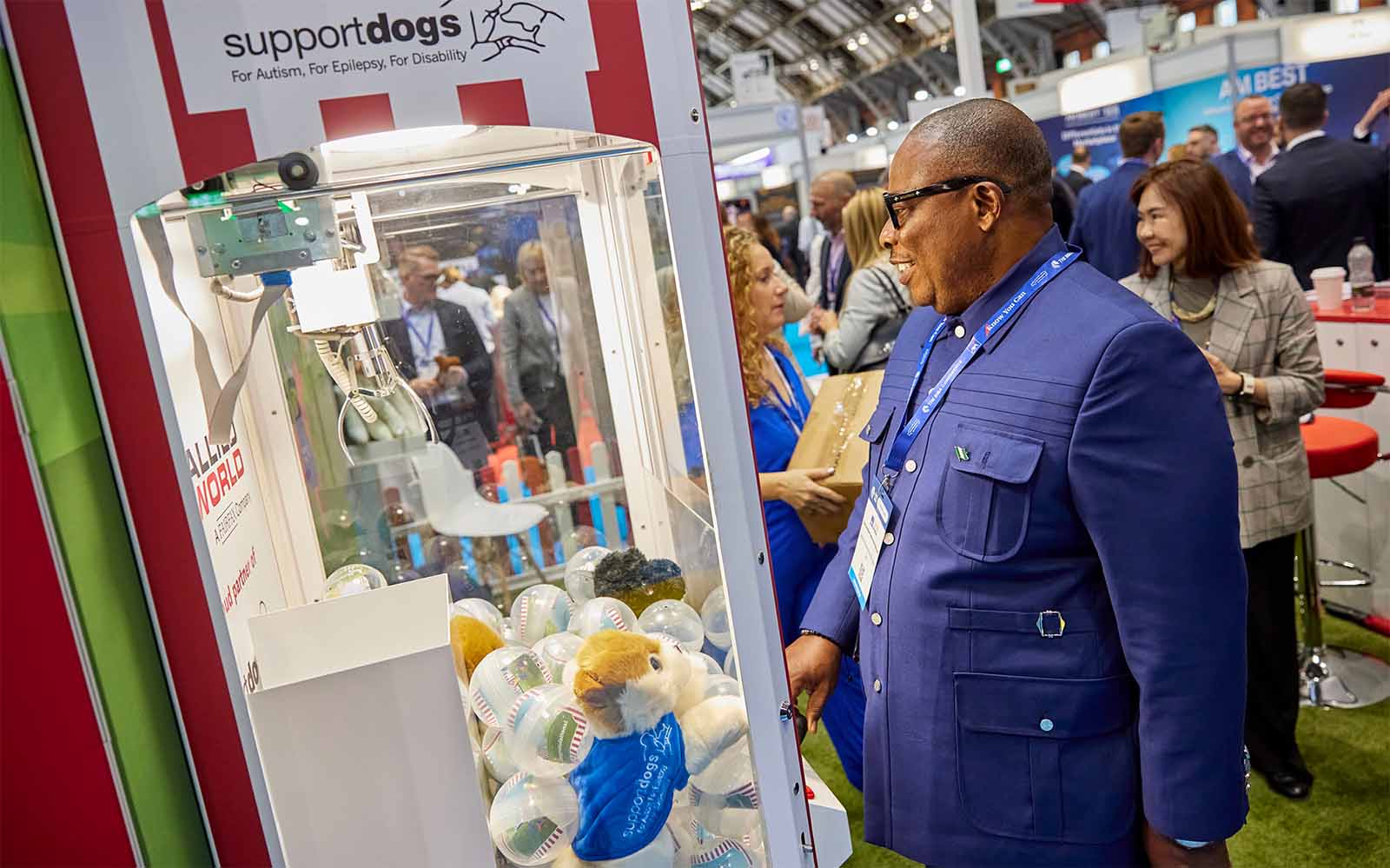 Man paying a claw machine on a conference stand