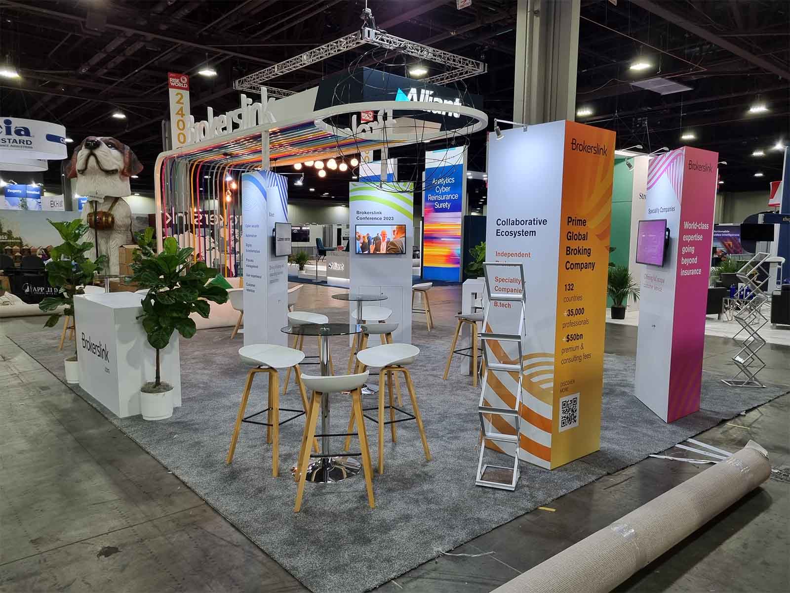 Split image. Left image shows hanging hats on a conference stand. Right image shows a dog in front of a conference stand