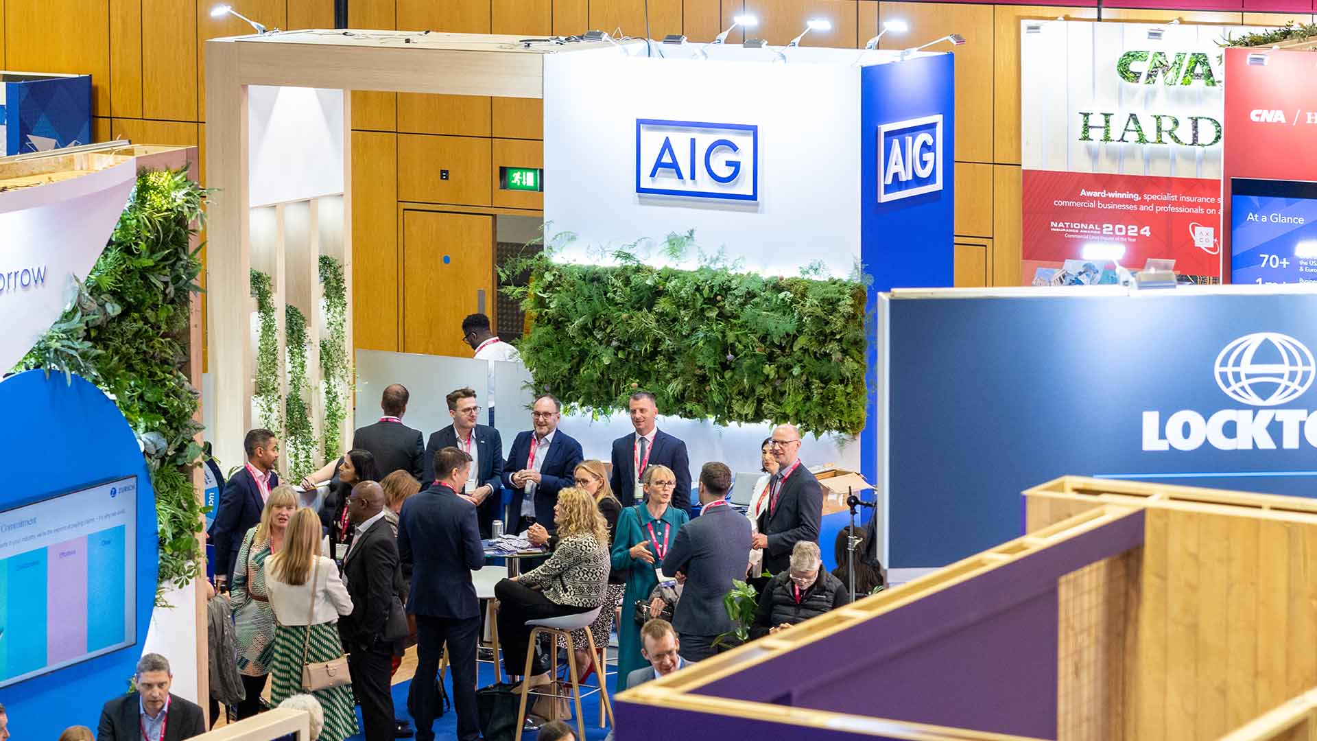 People congregated and networking in front of a conference stand