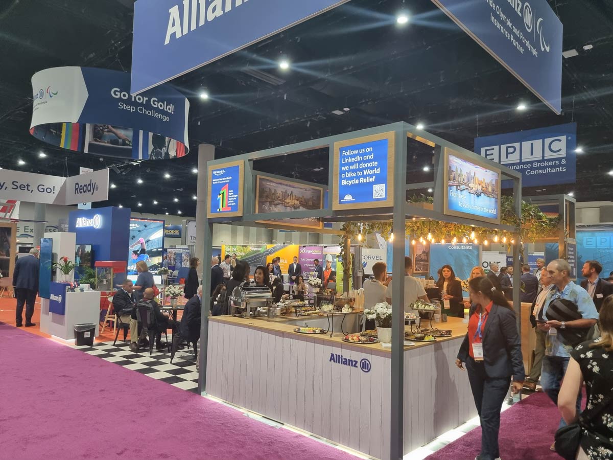 Numerous people networking and having meetings at a conference stand
