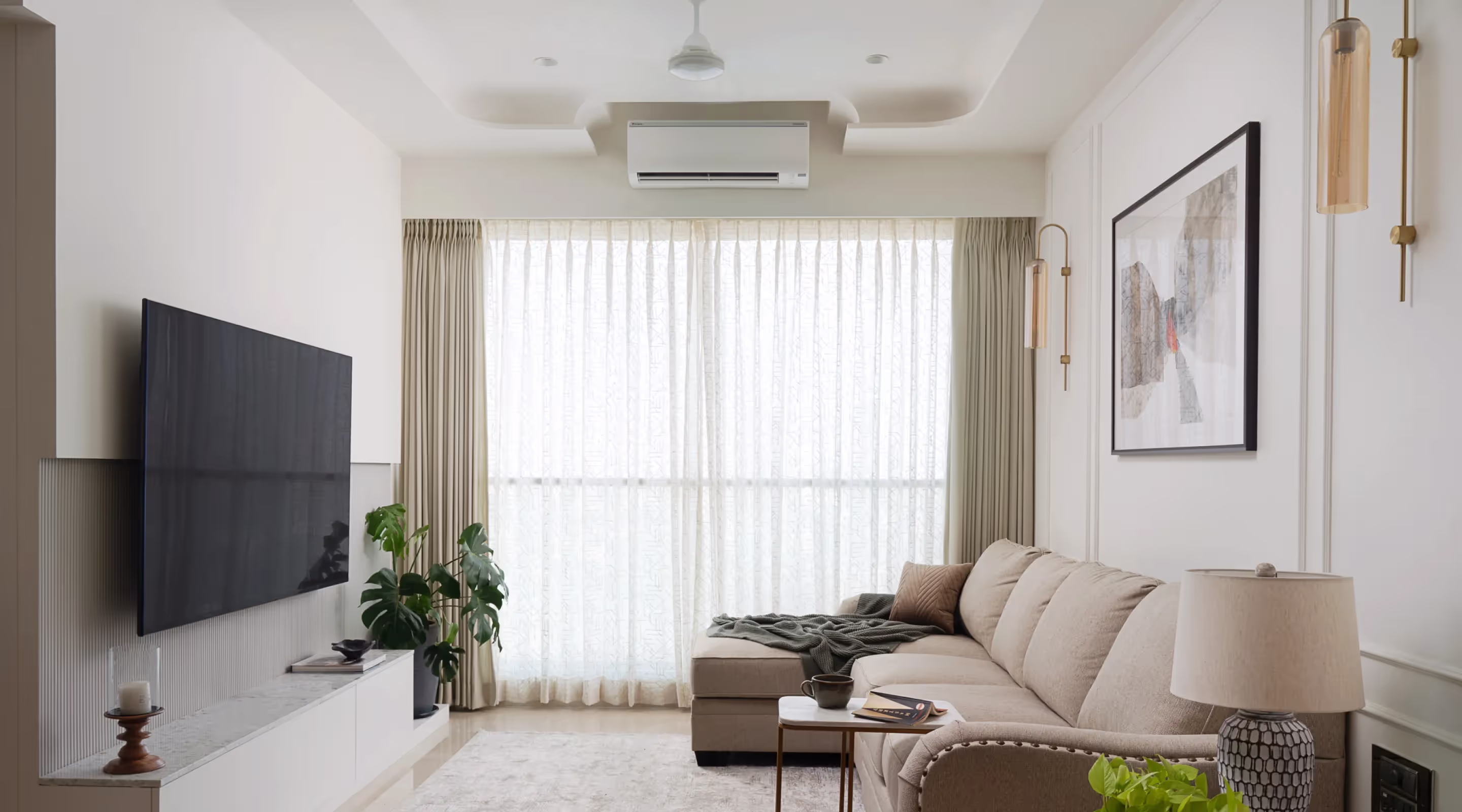 Living room set u with a warm beige sofa with a television mounted on the wall 