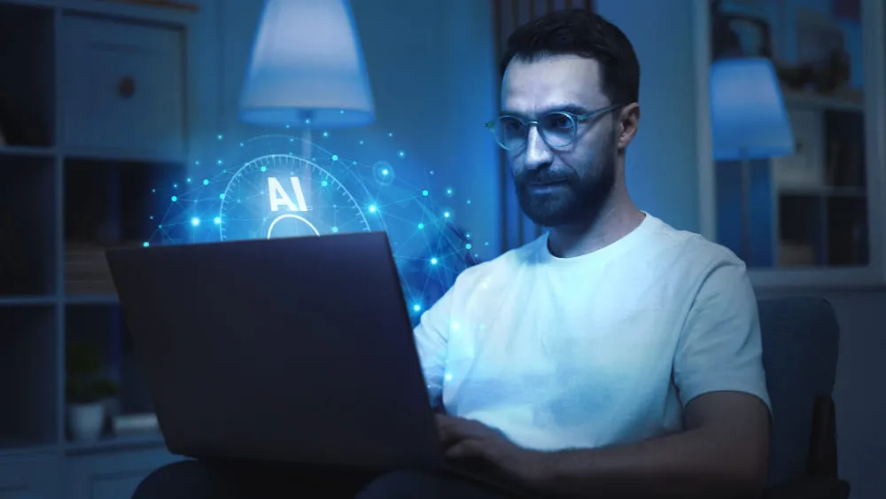 a man sitting in a chair using a laptop computer