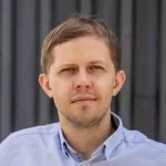 Vitalijus Dubietis, CEO of Verskis.lt, shown from the shoulders up, wearing a light shirt, looking toward the camera with a calm expression