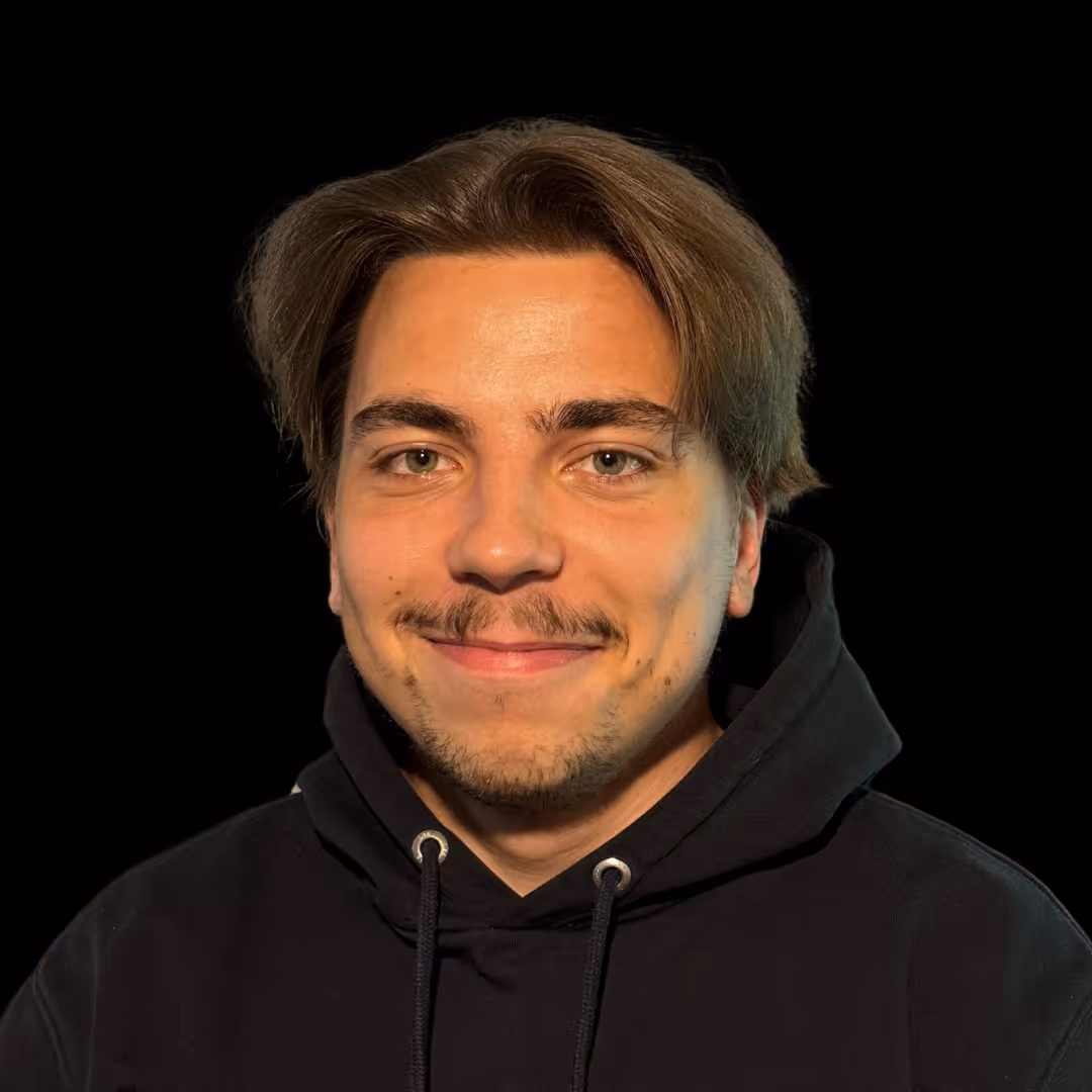 Ovi Sakalauskas, Head of Innovations, head-and-shoulders portrait with short brown hair and light facial hair, wearing a black hoodie, facing camera with a slight smile against a dark background.