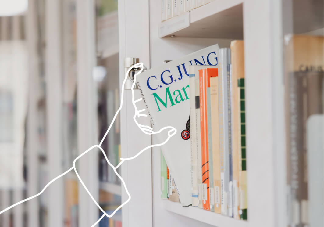 Strichfigur zieht ein Buch aus dem Regal, Buchrücken beschriftet „C.G. Jung".