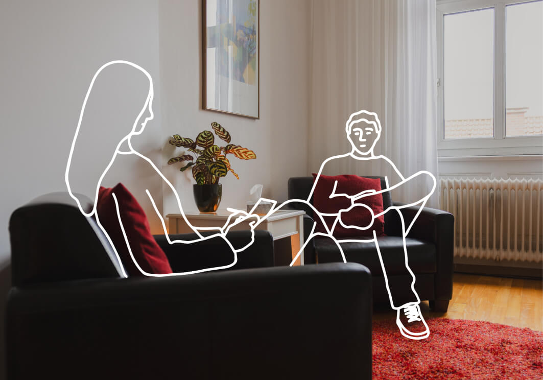 Eine Strichfigur liegt auf einem dunklen Sofa, eine zweite sitzt daneben – Therapiesituation.