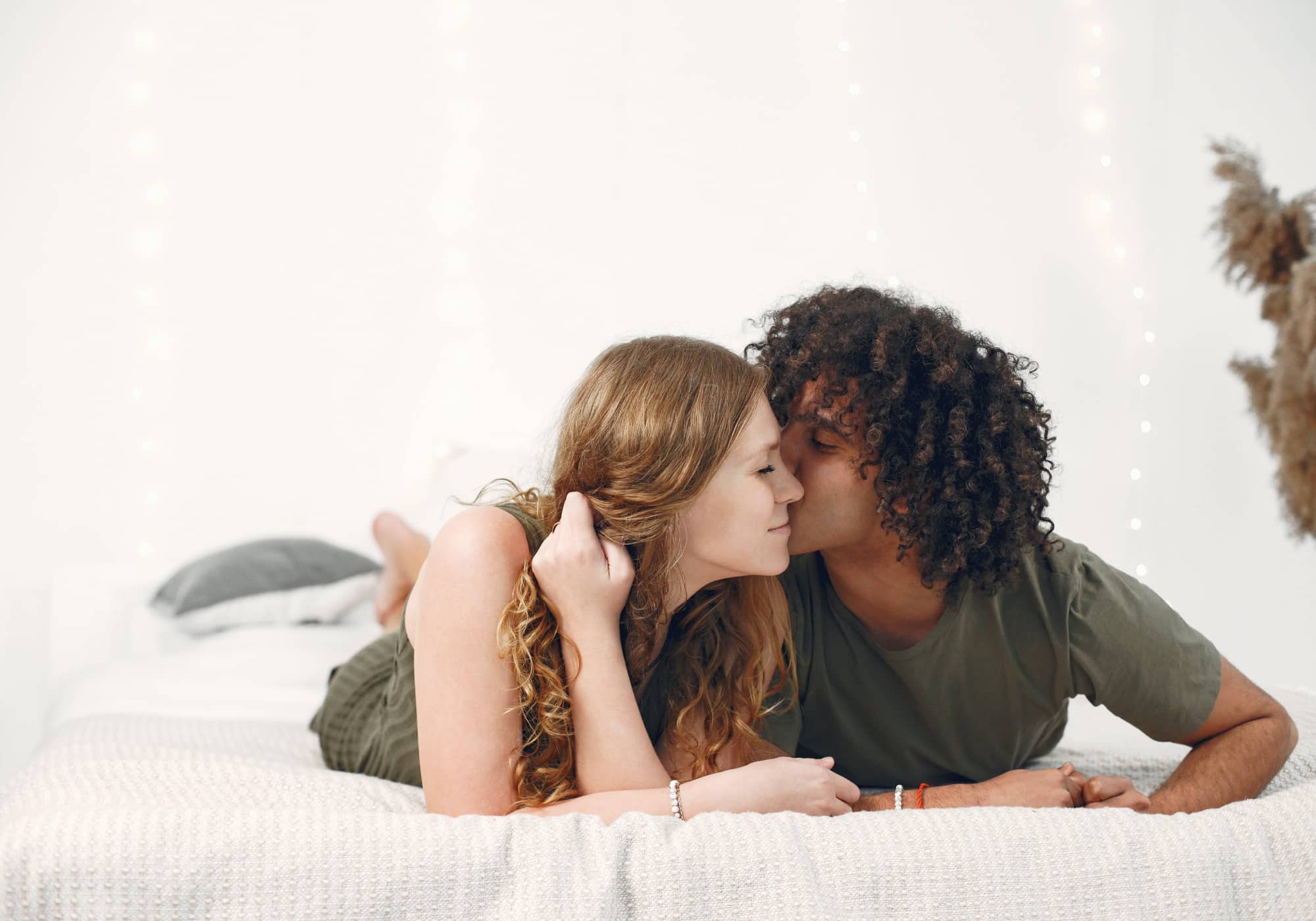 Smiling couple sharing a tender moment as the man kisses the woman on the cheek, symbolizing intimacy, trust, and different attachment styles in relationships.