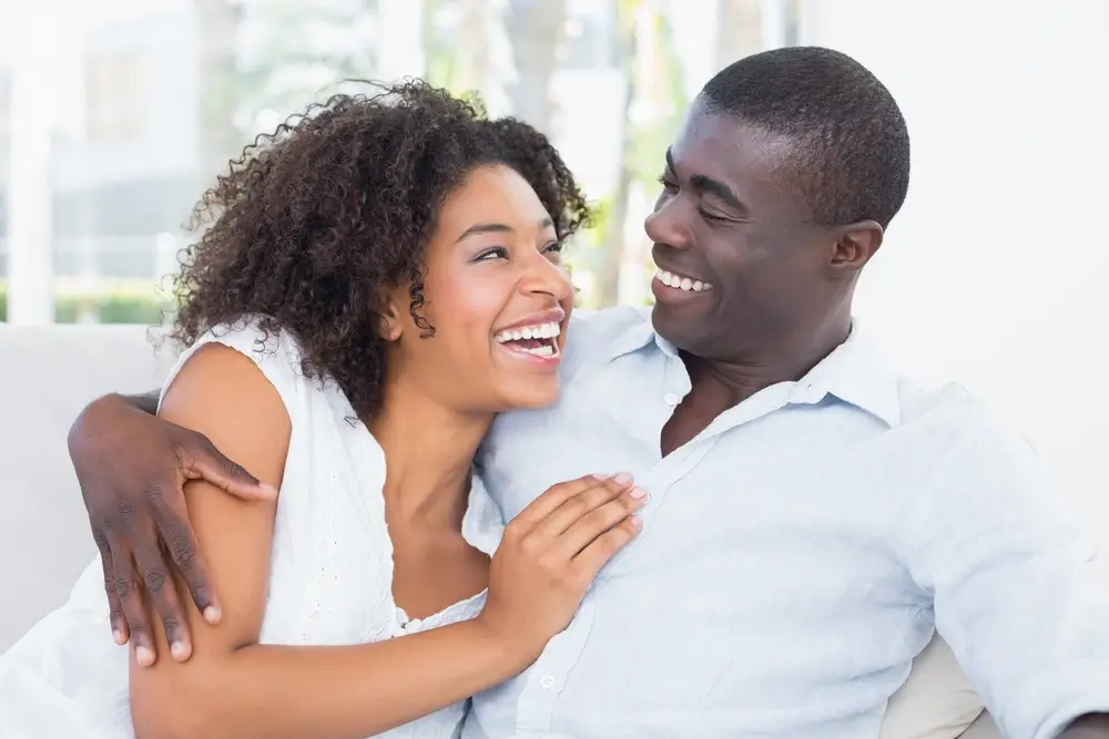 Couple cuddling on a couch, showing intimacy and trust.
