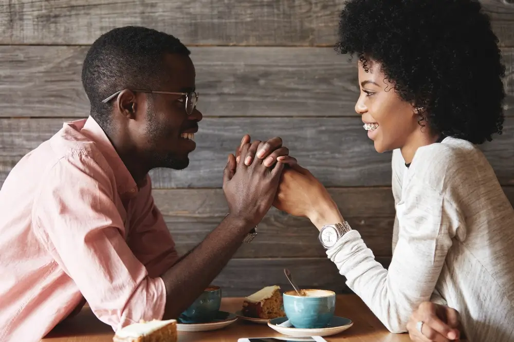 Couple talking at a coffee shop, showing healthy boundaries and respect.