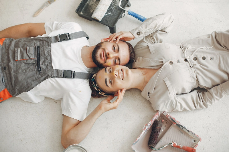 Young couple playfully repairing a room together, symbolizing relationship healing, empathy, and the process of forgiveness.