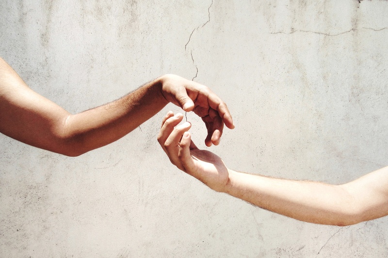 Close-up of two hands gently touching, symbolizing connection and empathy.