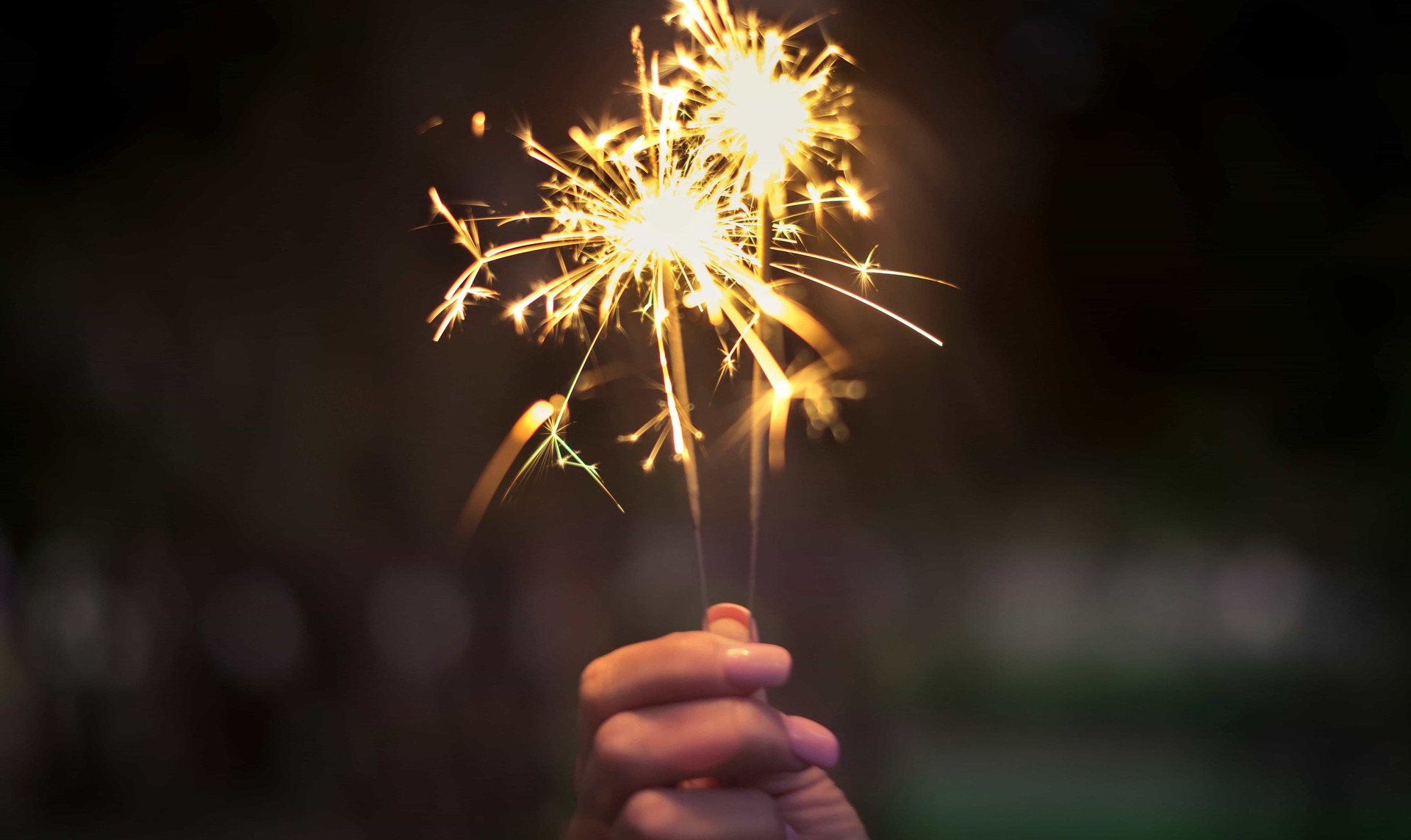 Close-up of sparklers glowing in the dark, small fireworks held in hand, symbolizing rekindling passion and keeping the spark alive in a relationship.