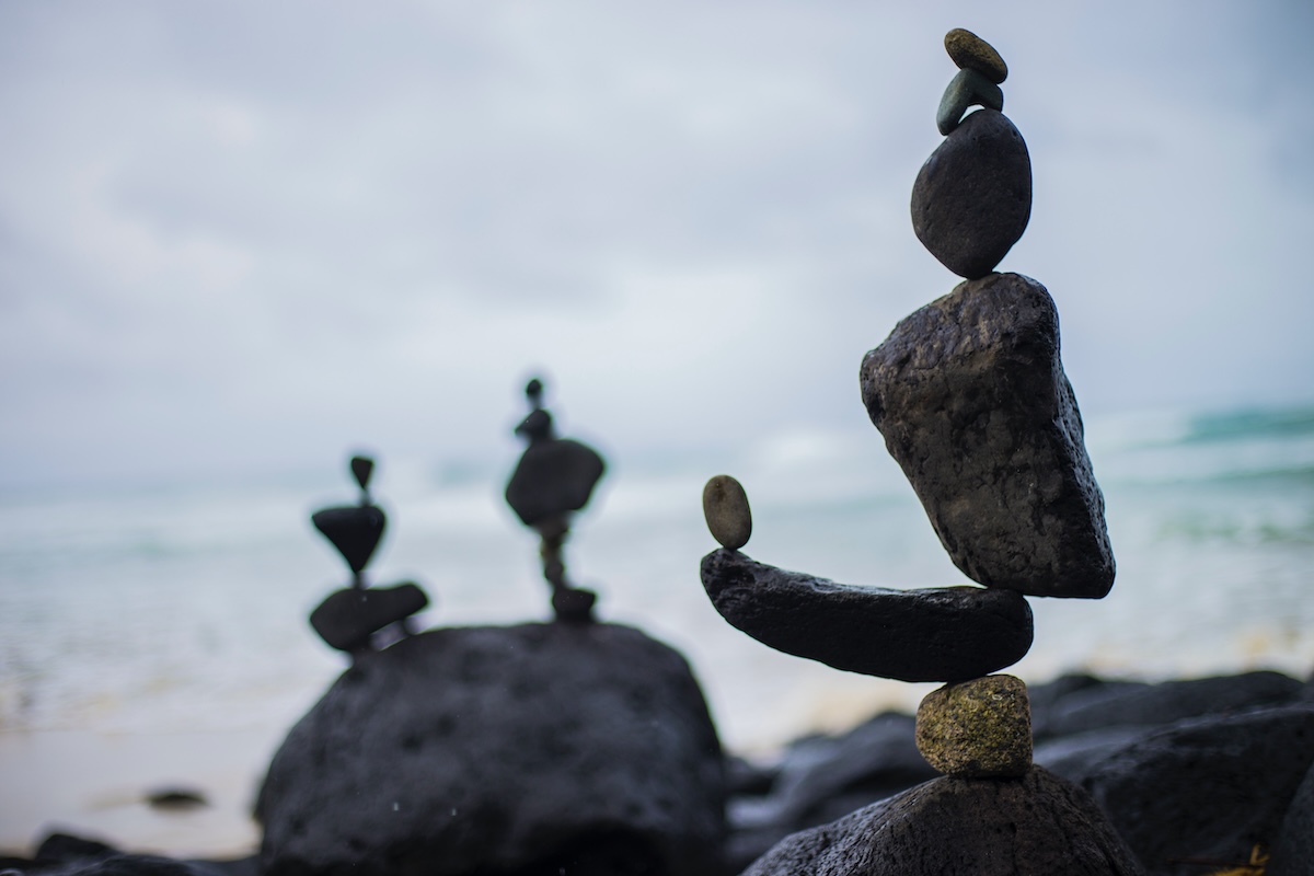 Balanced stack of smooth stones outdoors, symbolizing stability, mindfulness, and the delicate balance required in healthy relationships and conflict resolution.