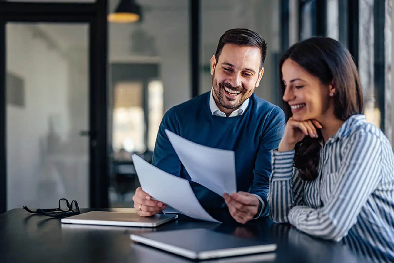 Two smiling co-workers, male and female