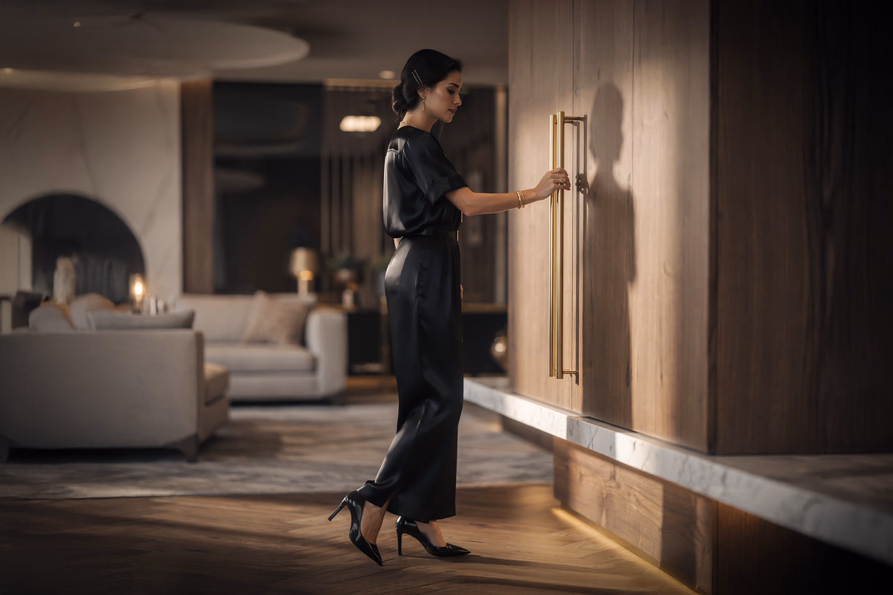 Elegant woman opening bespoke wooden cabinetry with brass-finish handles in a luxury Made in Italy interior.