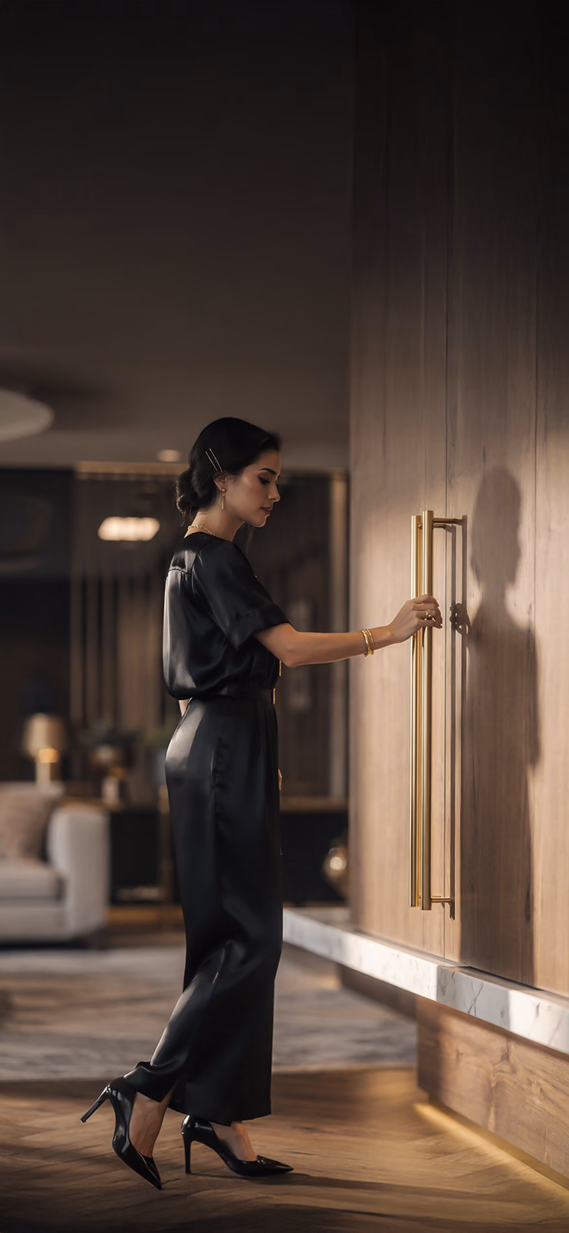 Elegant woman opening bespoke wooden cabinetry with brass-finish handles in a luxury Made in Italy interior.