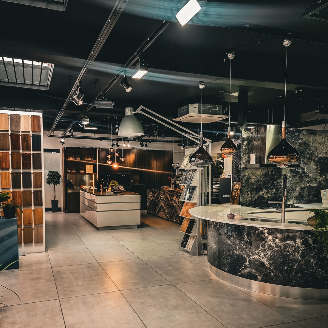 Modern kitchen showroom with marble counters and industrial lighting design