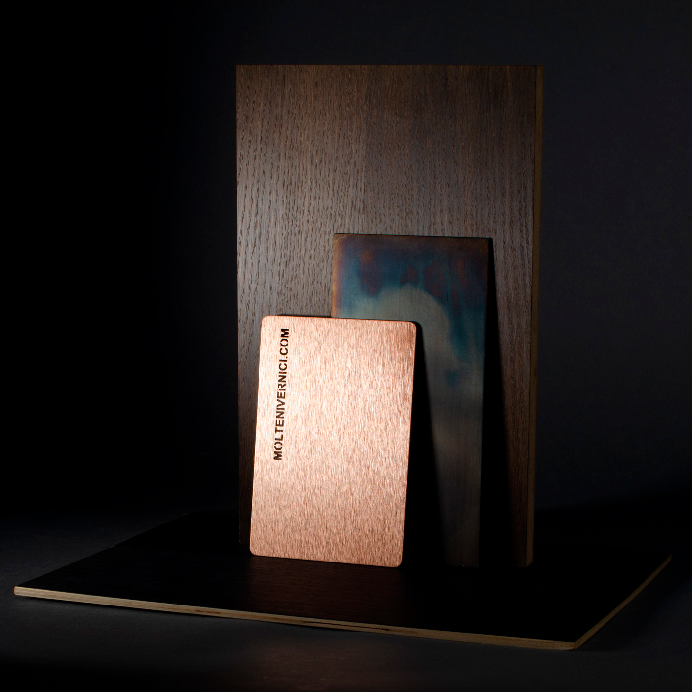 Carte métallique cuivrée Moltenwic.com sur fond en bois sombre