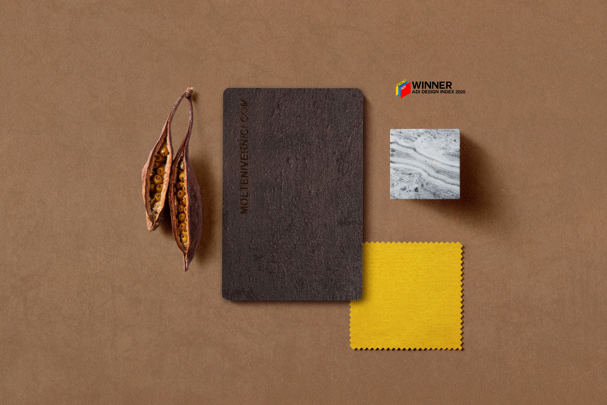 Dried seed pods, dark notebook, marble tile, and yellow fabric swatch