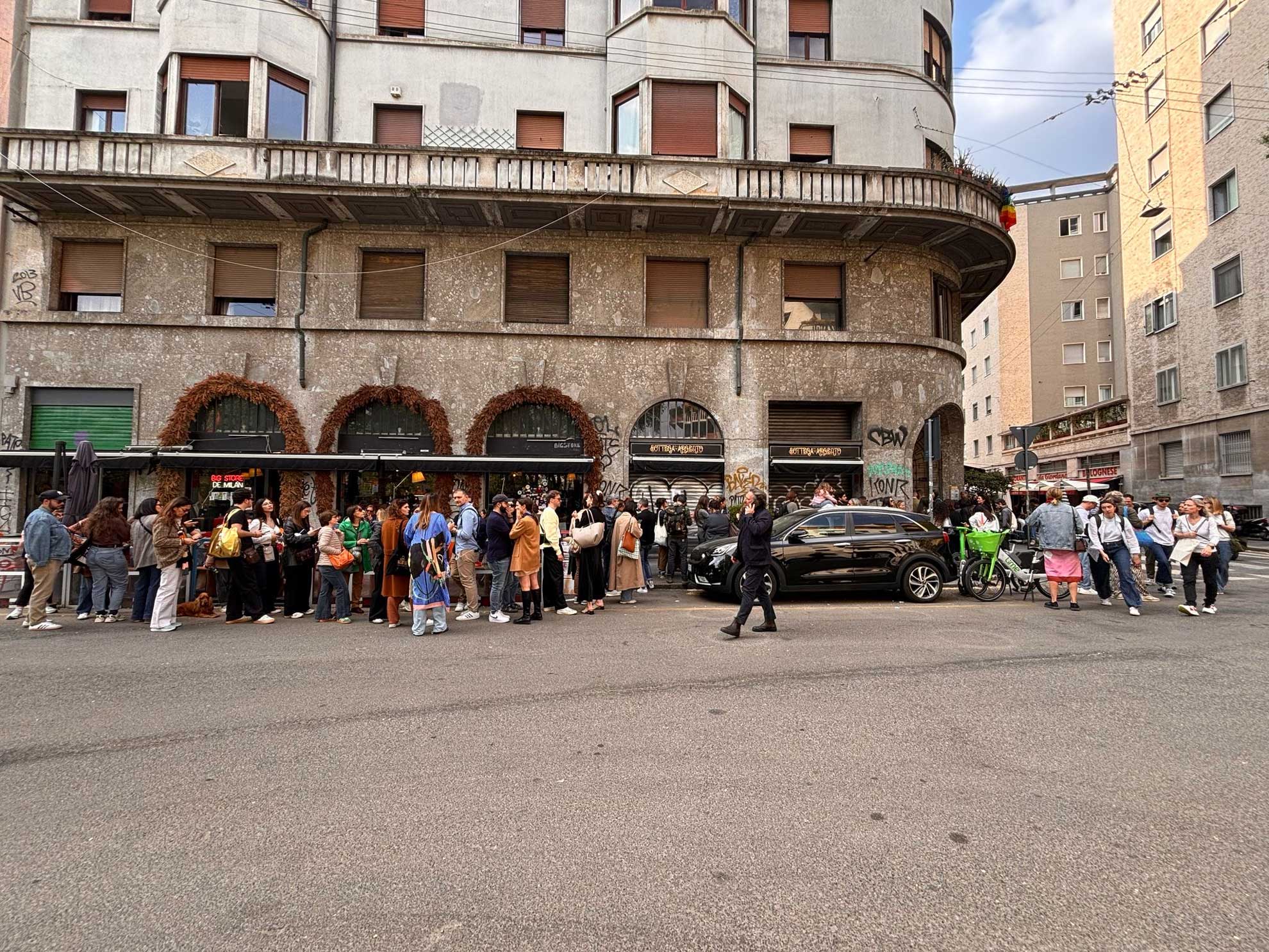 Foule animée devant un immeuble vintage dans une rue italienne urbaine