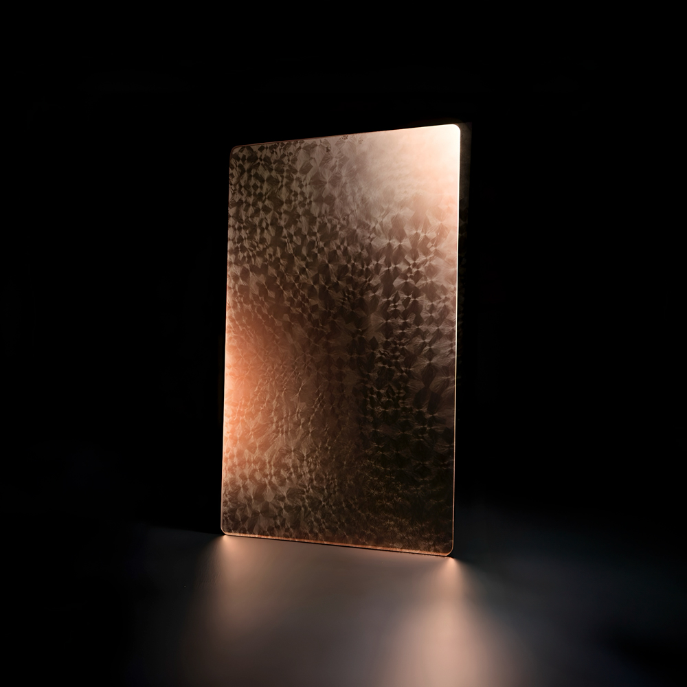 Plaque métallique texturée cuivrée avec reflets lumineux sur fond noir