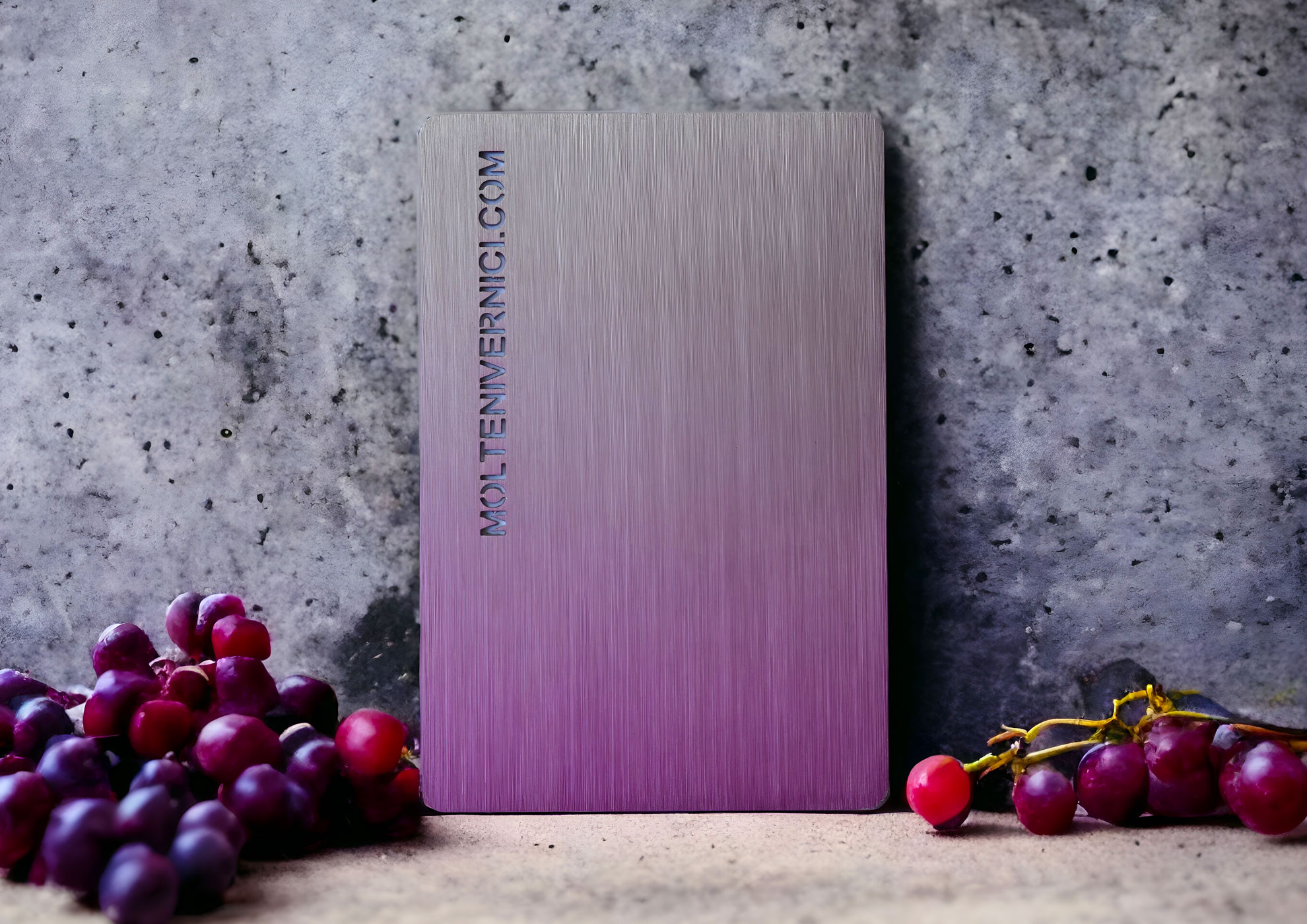 Livre de Moltenwernci.com avec des raisins violets sur un fond de béton