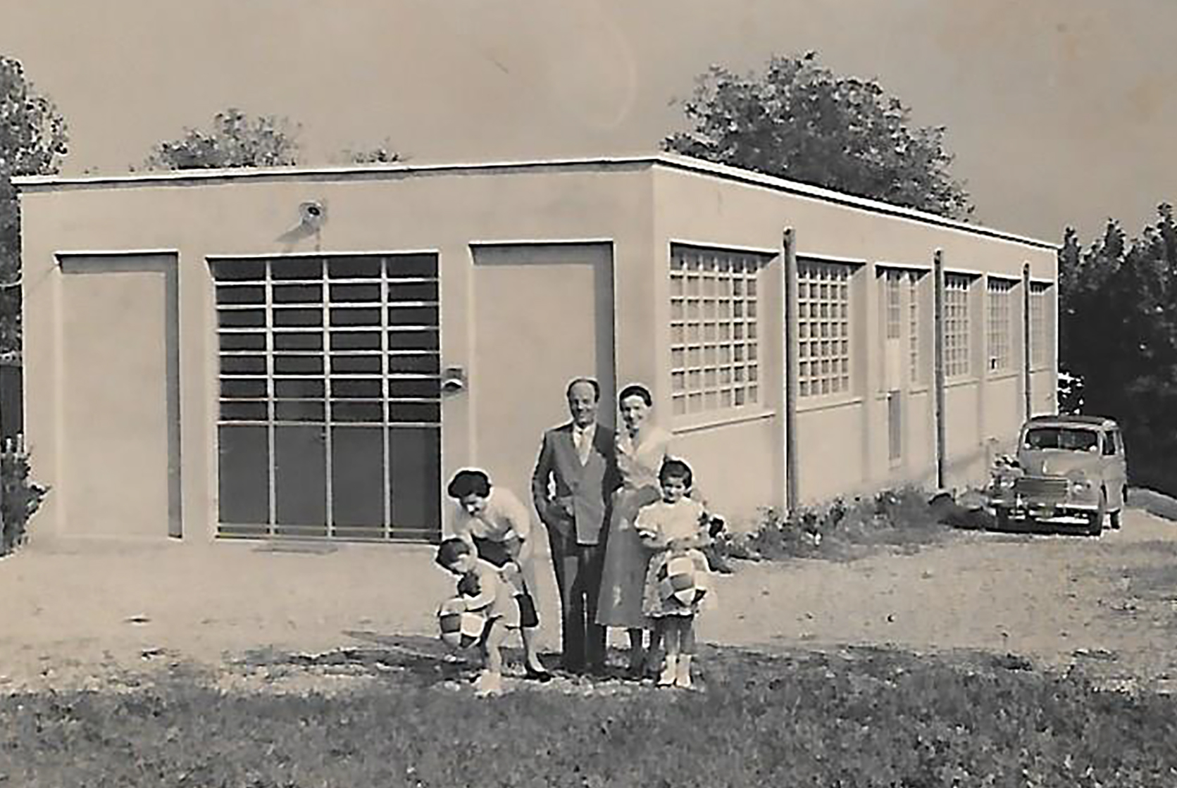 MOLTENI, VERNICI special paints factory with family in front of mid-century building