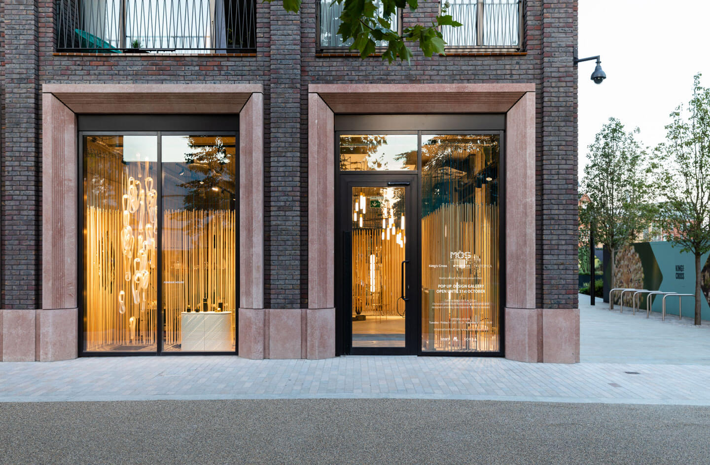 Fachada moderna de ladrillo con ventanas iluminadas y entrada elegante