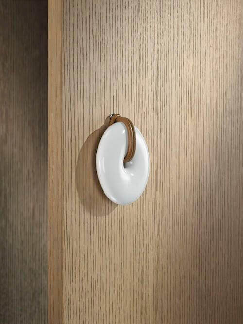 Tirador cerámico blanco MOLTENI-VERNICI con acabados especiales en madera