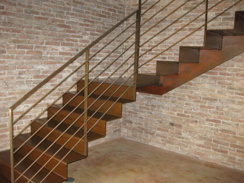Escalera metálica con acabados especiales MOLTENI-VERNICI sobre pared de ladrillo