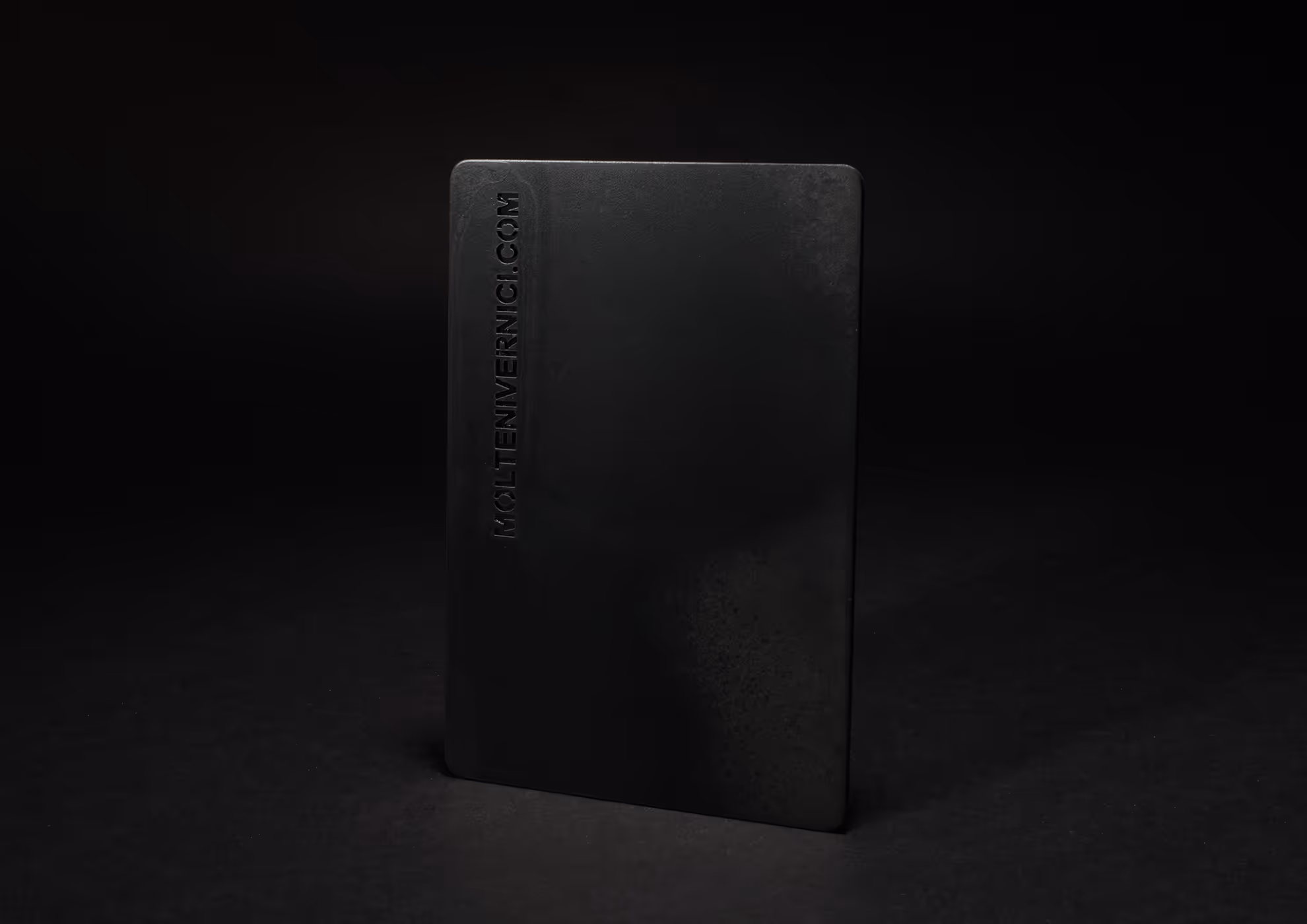 Tarjeta negra de MOLTENI-VERNICI con acabados mate sobre fondo oscuro